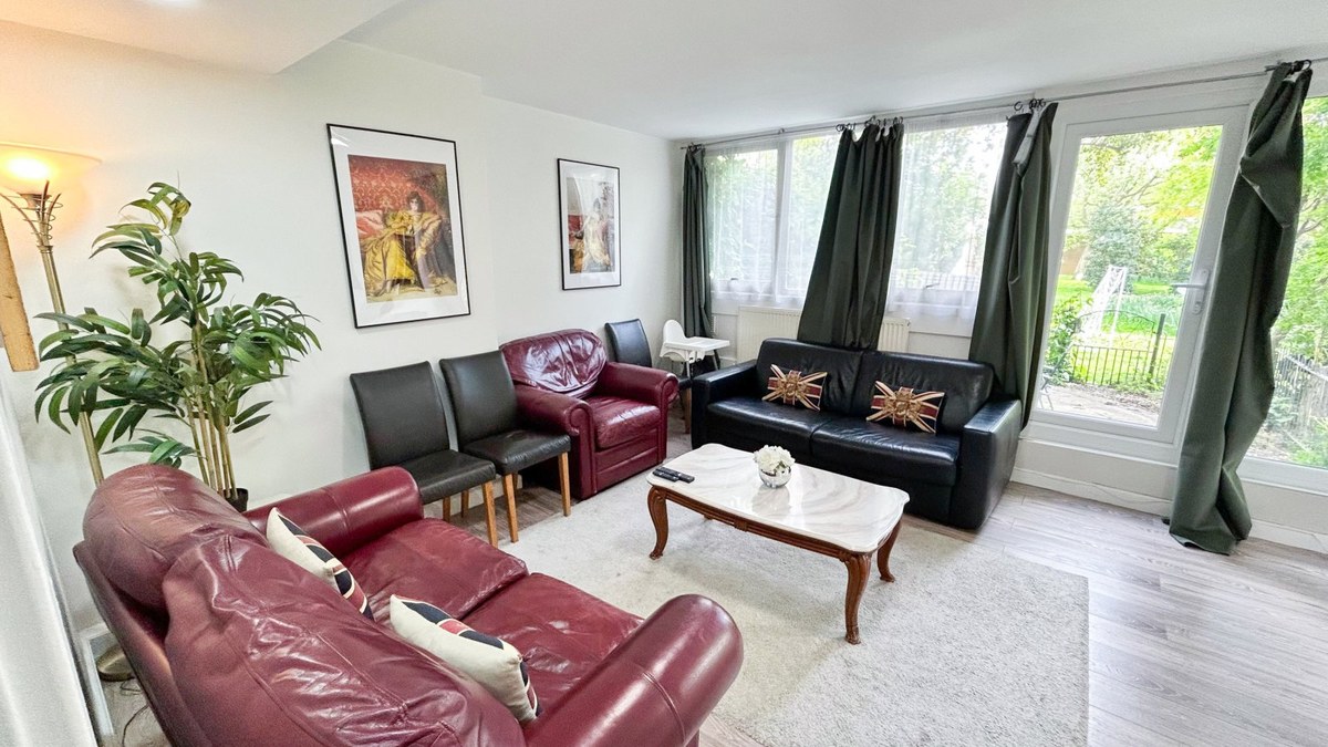 Living room with red and black sofas and garden-facing doors
