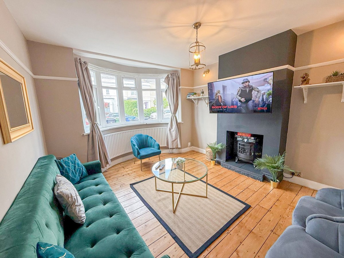 Living room with a green sofa, armchairs and a television